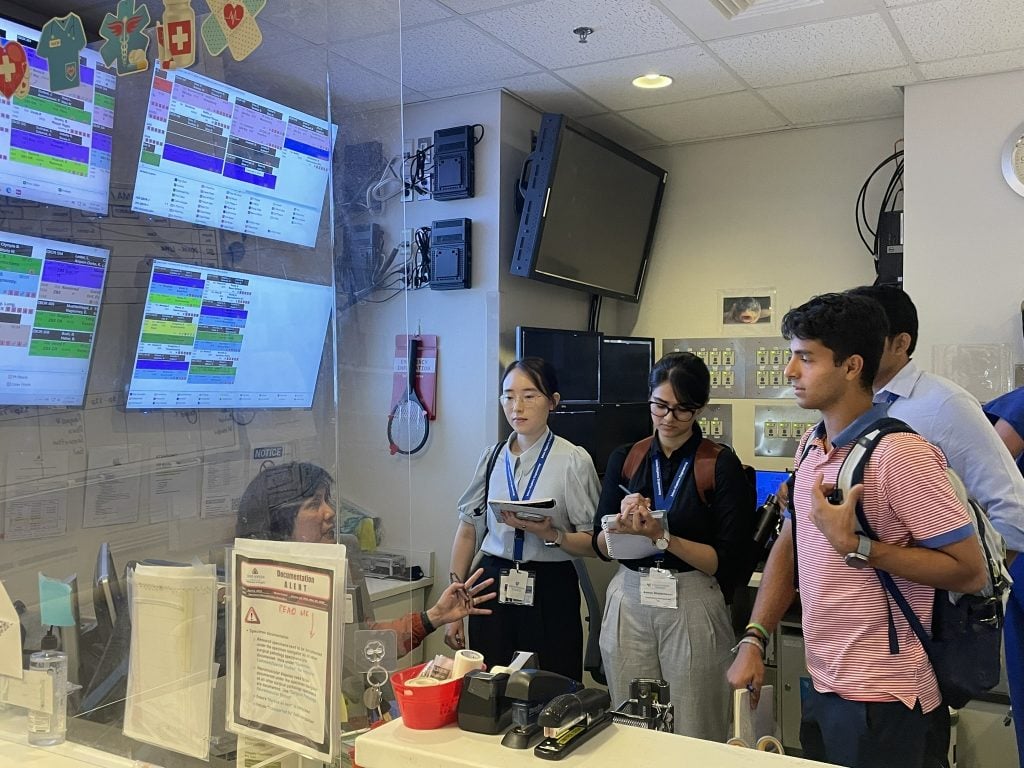 Four students interviewing hospital administrator in reception area of Johns Hopkins Hospital.