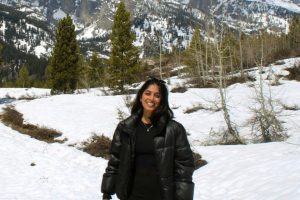 Shreya Gargya posing in front of a snowy mountain range.