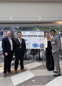 MSEM Director Trevor Mackesey and MSEM students standing in front of a research poster at Johns Hopkins Hospital.
