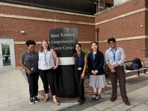 MSEM students next to the Sidney Kimmel Comprehensive Cancer Center sign at Johns Hopkins Hospital.