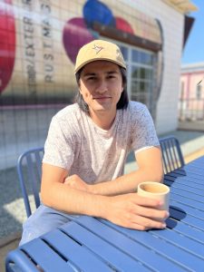 Tyler enjoying a cup of coffee on the patio of a cafe in San Diego, CA.